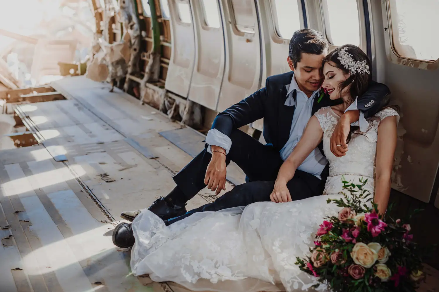Groom is hugging the bride in a crashed airplane after the wedding