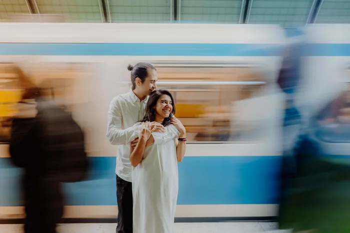 A couple hugging in front of a passing metro in Munich