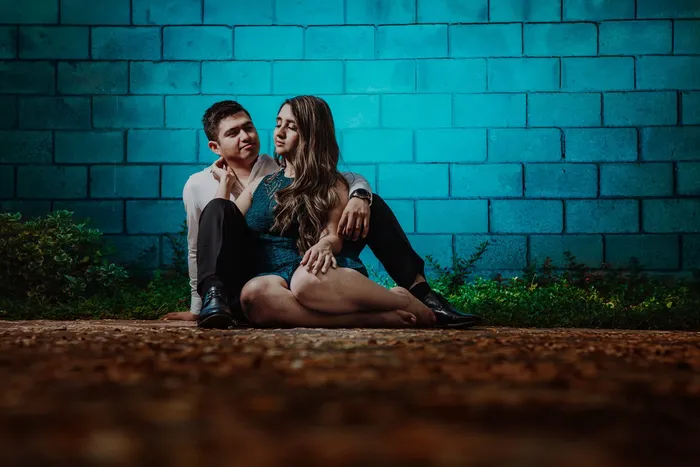 A couple sitting in front of a beautiful blue wall