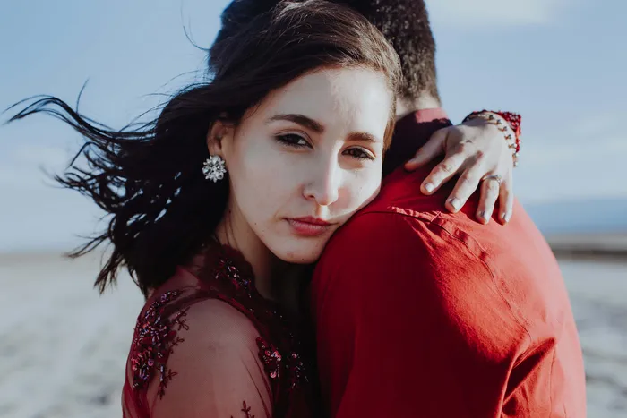 A girl looking at us while hugging her loved one
