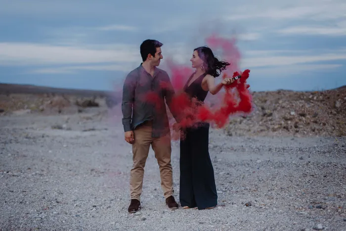 A couple standing in pink smoke