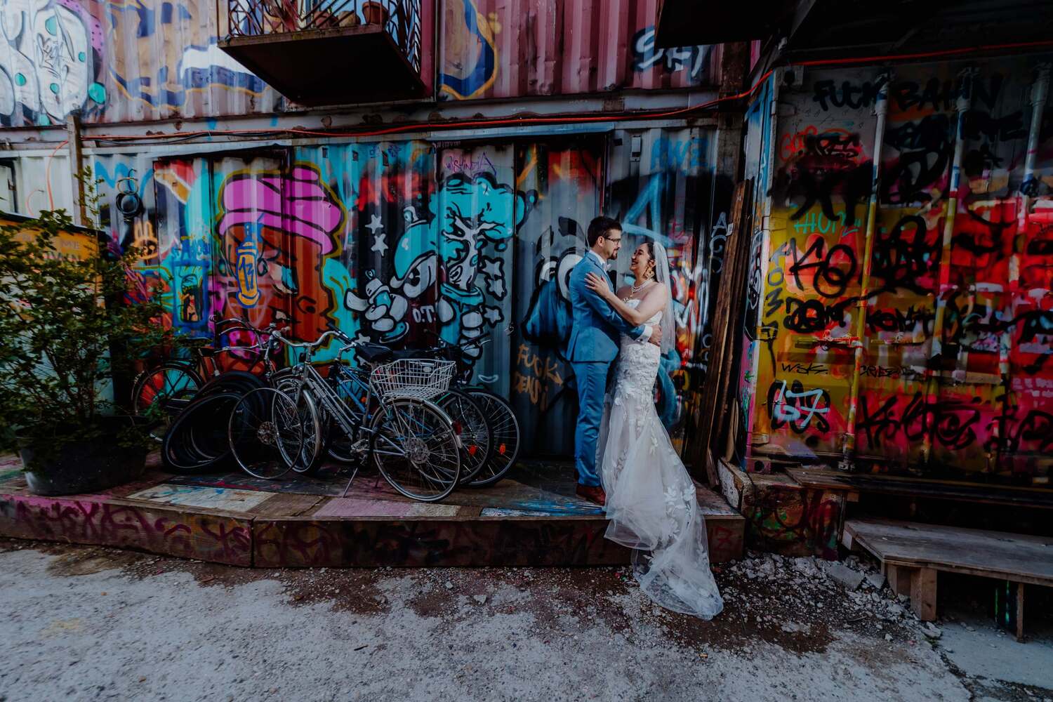 A couple hugging in front of graffiti in Munich after wedding