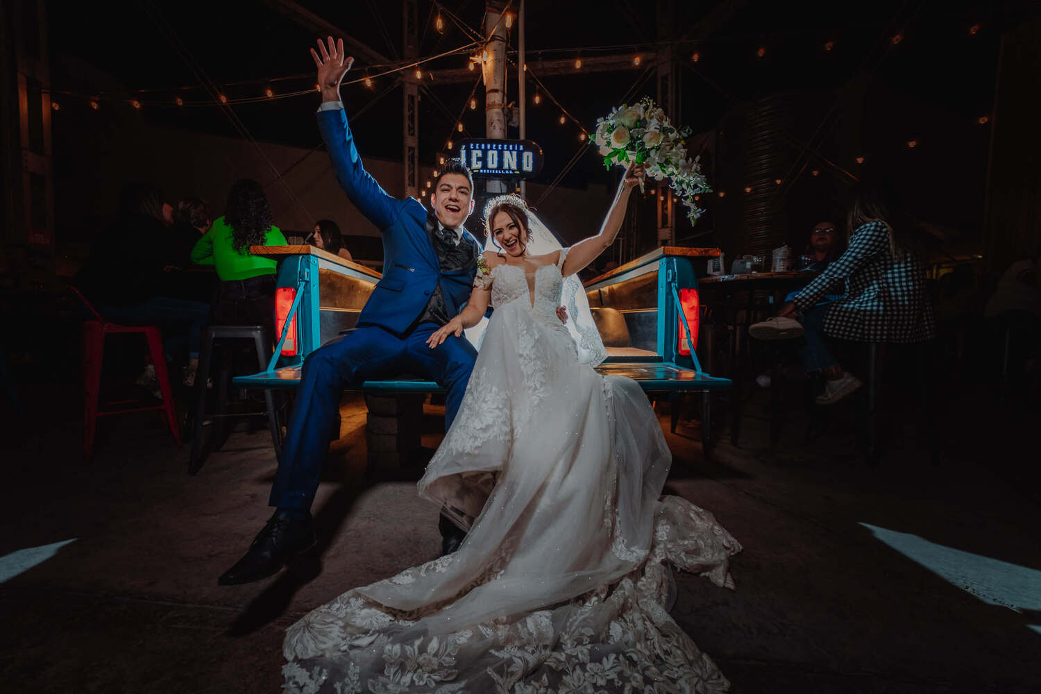 A just married couple raising hands in celebration in Mexico at their wedding.