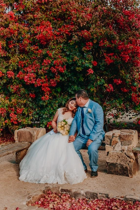 Married couple in front of flowers.